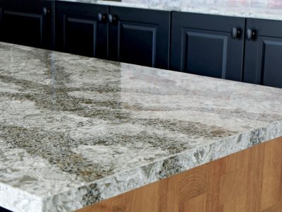 Close-up of a modern kitchen island featuring a polished quartz countertop with intricate patterns.