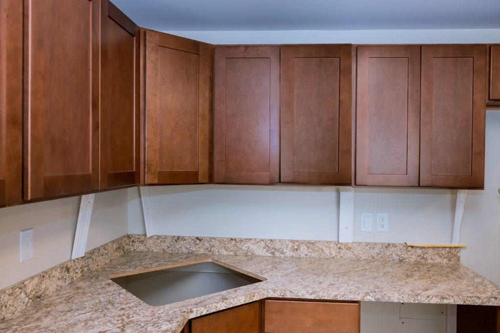 Kitchen with custom wooden cabinet doors and marble countertop.