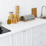 White kitchen counter with pasta jars and pot