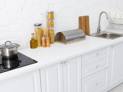 White kitchen counter with pasta jars and pot