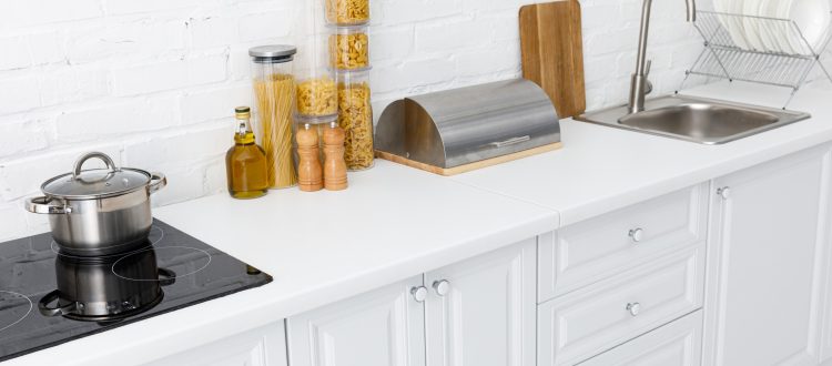 White kitchen counter with pasta jars and pot