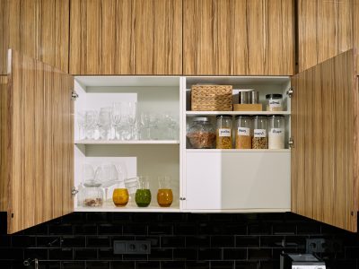 Open kitchen cabinet with glassware and jars