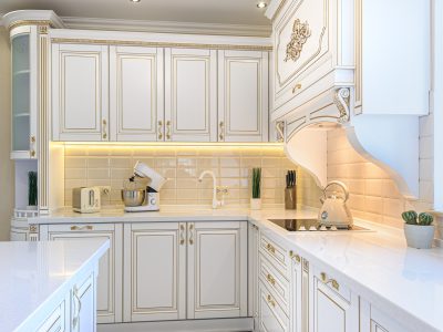 White kitchen cabinets with gold trim and appliances