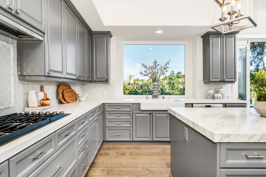 Gray kitchen cabinets with large window view
