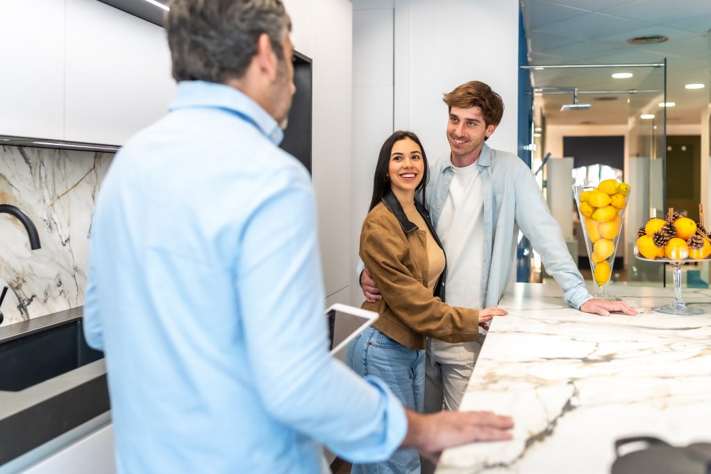 Couple talking to agent in modern kitchen