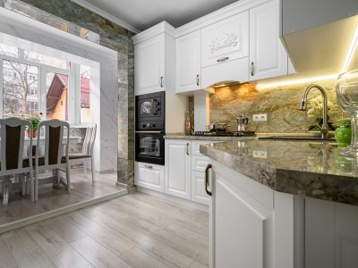 White kitchen with marble countertops and dining area